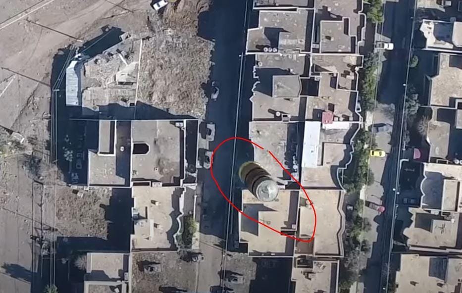 An explosive device being dropped by a cheap commercial drone in Syria in 2017. Photo from 'Newsly.com'